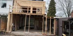 Aanbouw in houtskeletbouw tijdens verbouwing van woning, casco met houten balken en kozijnopeningen door AanbouwMaximaal