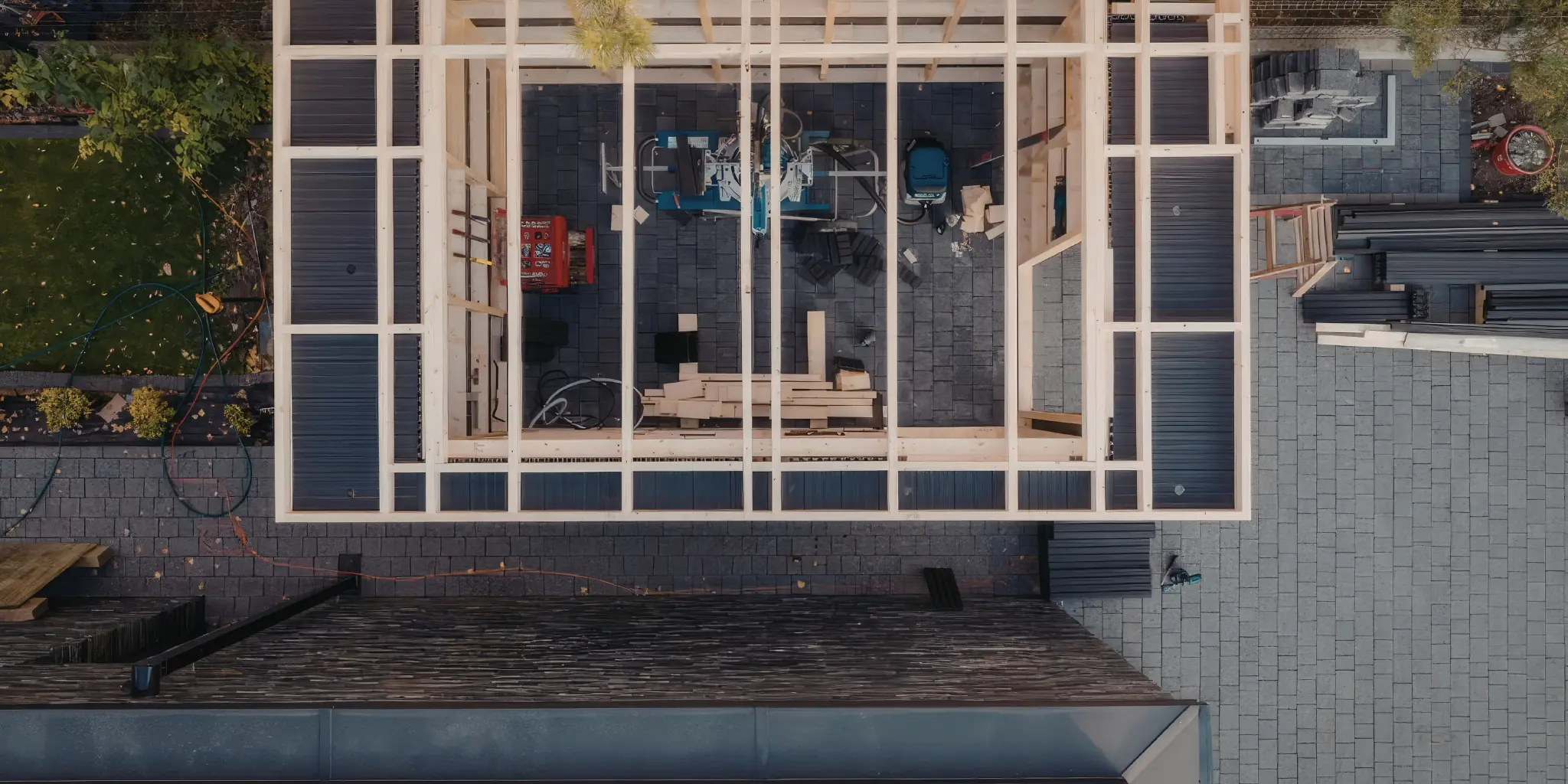 Luchtfoto van een traditioneel gemetselde uitbouw in aanbouw met houten balkframe achter een woning